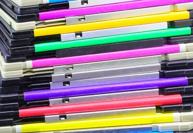 1990 'lardan kalma bilgisayar verilerini depolamak için mavi yeşil, pembe ve mor gibi çeşitli canlı renklerde klasik disketler yığını