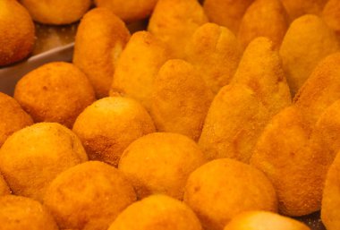 Yakın çekim birçok altın kahverengi kızarmış kroket veya pirinç topları tepsisi veya arancini veya arancine olarak bilinen geleneksel İtalyan sokak yemekleri tabağı