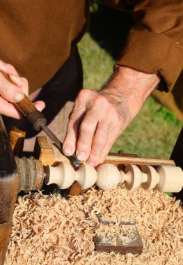 Yetenekli zanaatkar parmakları antik torna ve keski aletleriyle ahşap parçaları işliyor.