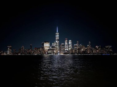 Manhattan 'ın aşağısındaki muhteşem New York şehri New Jersey' den gece Hudson nehri manzaralı.
