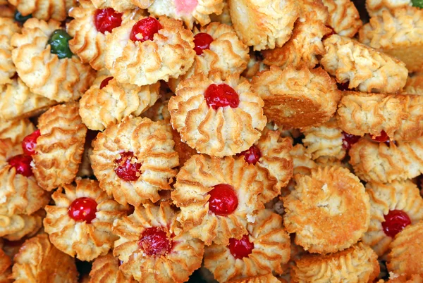 Birçok hamur işleri ve buzlanma ile badem bisküvi ve şekerlenmiş meyve — Stok fotoğraf