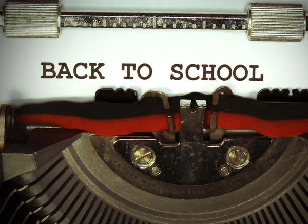 Voltar para a escola escrito com tinta preta com a velha máquina de escrever — Fotografia de Stock