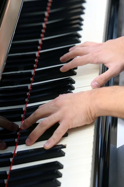 Mano de pianista joven mientras toca el teclado del piano —  Fotos de Stock