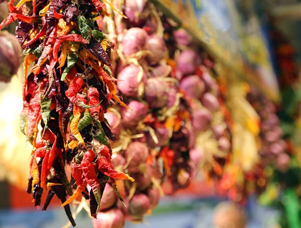 Grinaldas de alho penduradas na loja do mercado vegetal — Fotografia de Stock