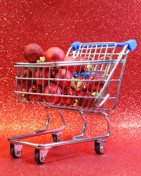 Winkelwagen met rode decoratieve kerstballen en glitter ba — Stockfoto