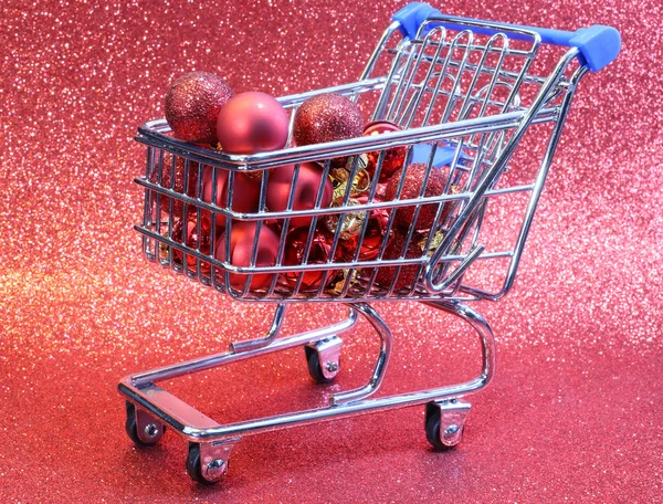 Weinig winkelwagentje met rode decoratieve kerstballen — Stockfoto