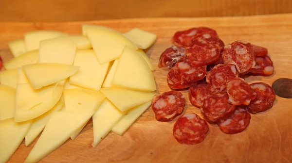 Cutting board with cheese and salami — Stock Photo, Image