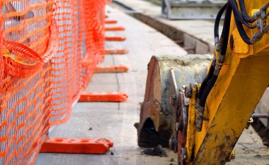 excavator digging on the road during the work of laying an optic clipart