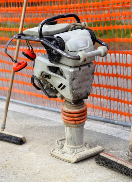 Verdichtungsplatte in einer Straßenbaustelle mit Sicherheitsnetz — Stockfoto