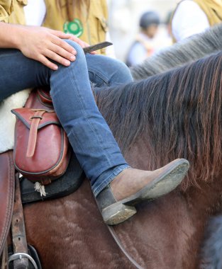 kovboy çizmeleri ve kot pantolon ile at arka üzerinde rahatlatır