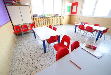 nursery classroom with school desks and small red chairs clipart