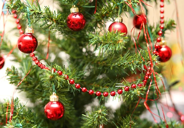 Red glass balls decorate a large Christmas tree — Stock Photo, Image