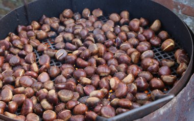 many chestnuts roasted on the fire on the road in winter