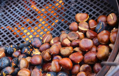 many chestnuts roasted in giant pan on the fire from a street ve