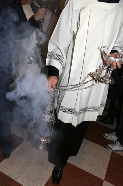 Sacerdote em batina abençoa os fiéis com incenso — Fotografia de Stock