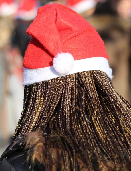 Młoda kobieta z włosy w warkocze i czerwona czapka Świętego Mikołaja w wi — Zdjęcie stockowe