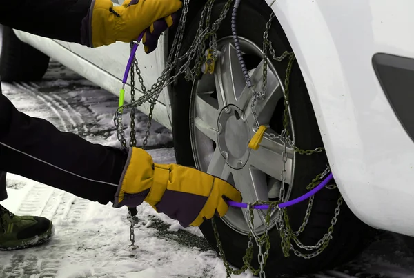 Chaînes à neige dans le pneu de la voiture en hiver sur la neige — Photo