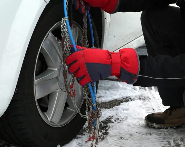 Homem montagem correntes de neve no pneu do carro no inverno na neve — Fotografia de Stock