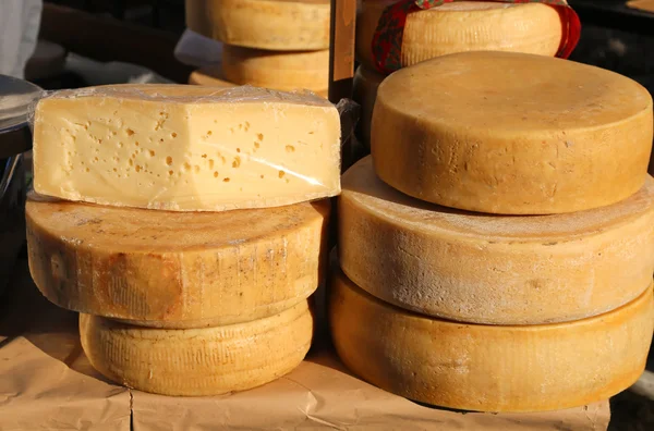 Sabroso queso maduro con agujeros para la venta en el mercado —  Fotos de Stock