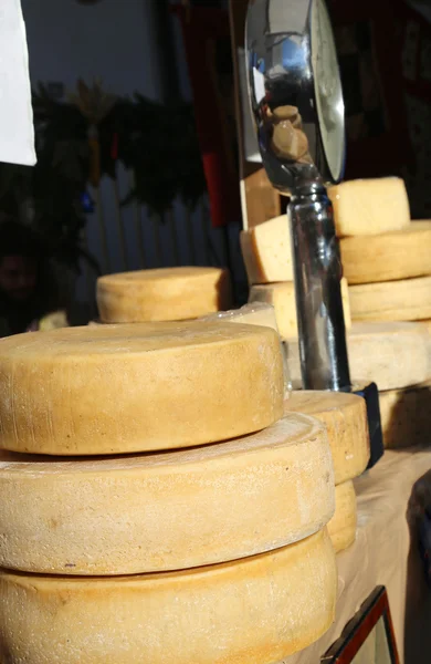 Bench of cheese and a balance in the local market — Stock Photo, Image