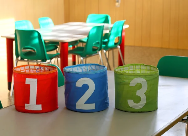 Cans with large numbers on the desk in the classroom — Stock Photo, Image