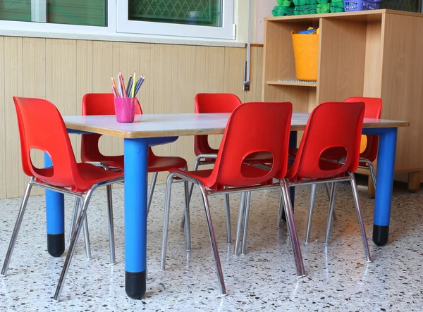 Klassenzimmer eines Kindergartens mit roten Stühlen und kleiner Schultasche — Stockfoto