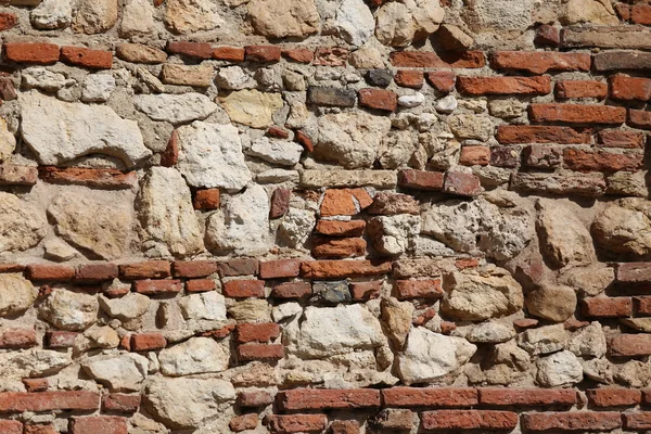 Oude muur van stenen en rode bakstenen met kalk en cement — Stockfoto