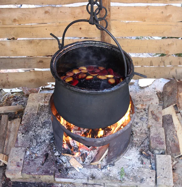 Big blackened pot to cook the tasty mulled wine in the european — Stock Photo, Image