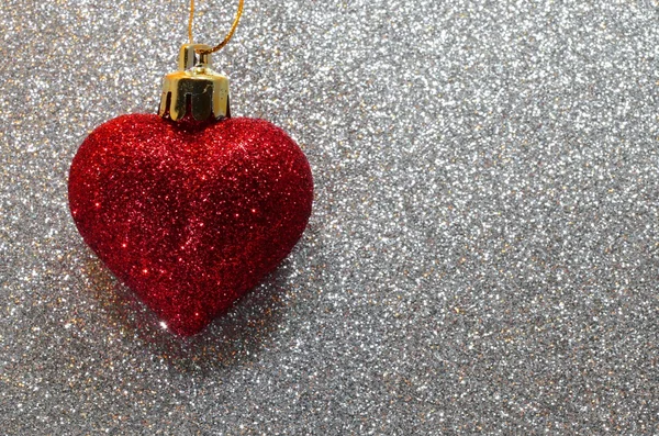 Een eenzame rood hart op de achtergrond glitter zilver — Stockfoto