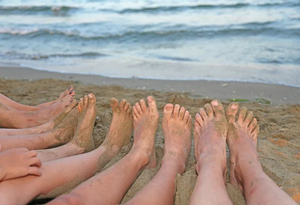 Voeten van een groot gezin aan de oever van de zee in de zomer — Stockfoto
