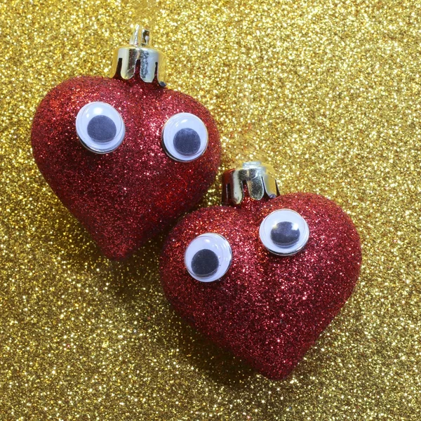 Two hearts with eyes in the golden background glitter — Stock Photo, Image
