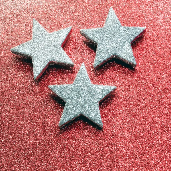 Drie zilveren sterren op rode achtergrond verlicht — Stockfoto