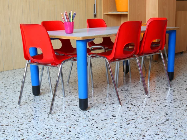 Aula de un jardín de infantes con sillas rojas y pequeñas mesas —  Fotos de Stock