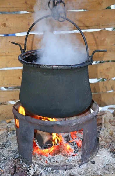 Großer schwarzer Topf mit angezündetem Feuer und dichtem weißen Rauch — Stockfoto