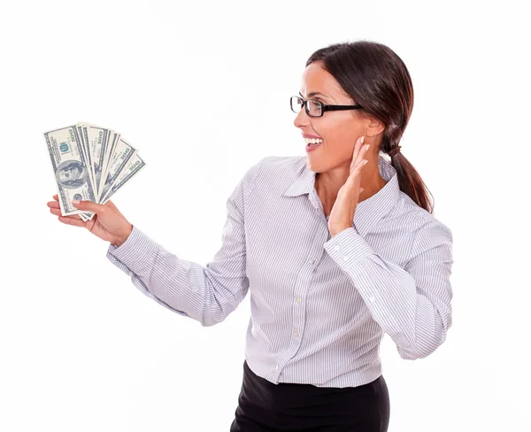 Mulher morena impressionada segurando notas de dólar — Fotografia de Stock