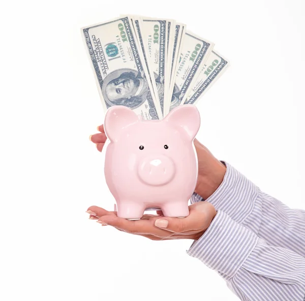 Piggy bank en dollars in handen — Stockfoto