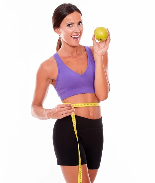 Woman with apple measuring waist — Stock Photo, Image