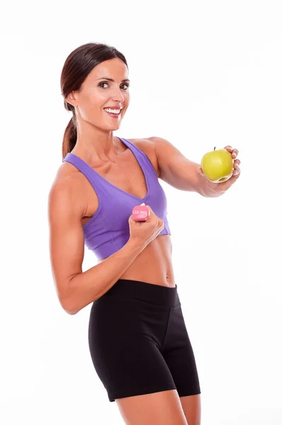 Woman with dumbbell and apple Stock Picture