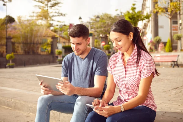 Pareja joven sentada en la plaza — Foto de Stock