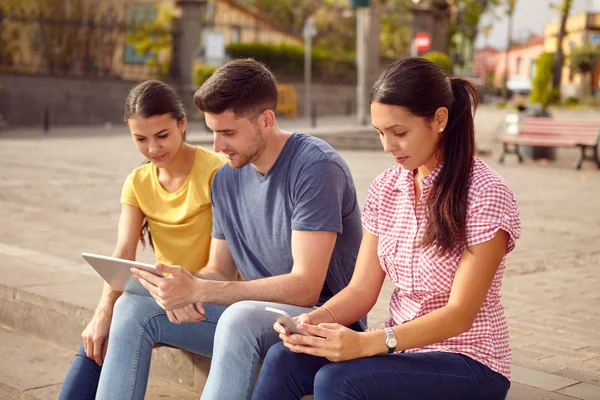 Jóvenes sentados en la plaza — Foto de Stock