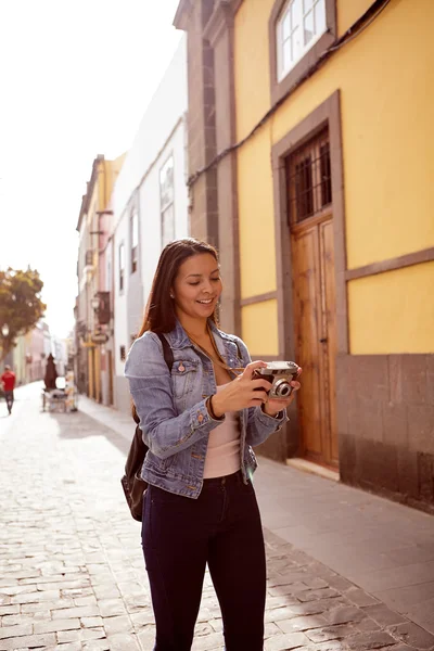 Женщина, идущая в город с камерой — стоковое фото
