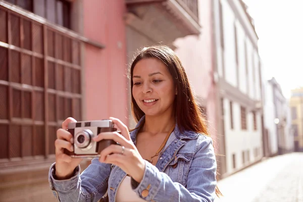 Chica bonita mirando la foto en su cámara — Foto de Stock