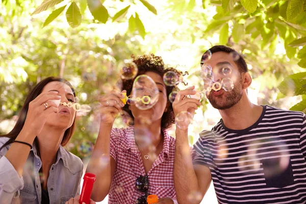 Giovani amici che soffiano bolle — Foto Stock