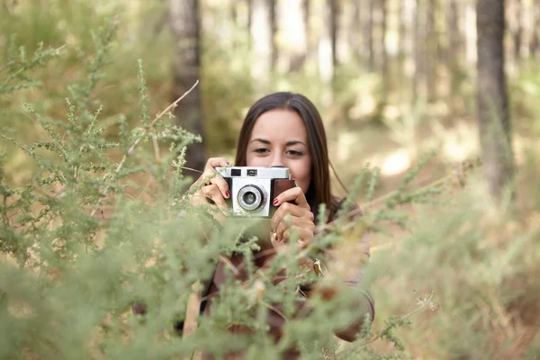 girl taking picture in forest