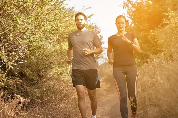 Jonge vrienden joggen op pad — Stockfoto