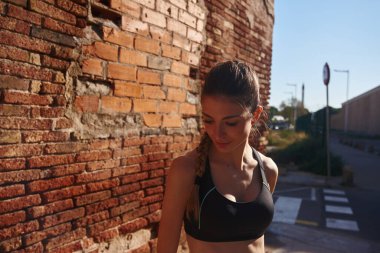 Siyah kolsuz bluz giyen genç, siyah saçlı bir kadın...