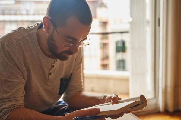 Intrigued Middle Age Man Slouching Reading Book While Sitting — Stock Photo, Image