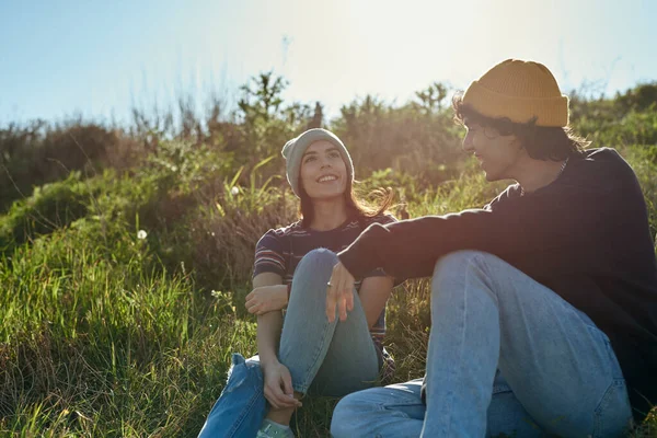 Zwei Strahlende Junge Leute Sitzen Auf Einem Hügel Und Unterhalten — Stockfoto