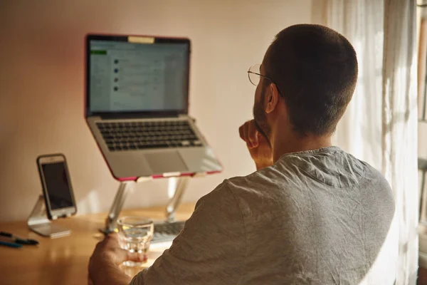 Contemplative Man Looking Directly His Laptop One Hand His Chin — Stock Photo, Image