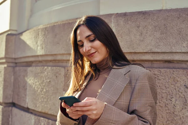 Uma Senhora Despreocupada Fora Mensagens Texto Enquanto Inclina Contra Uma — Fotografia de Stock